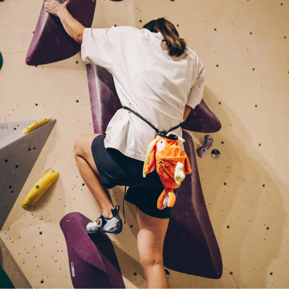 Female Climber with Novelty Chalk Bag on Boulder Wall