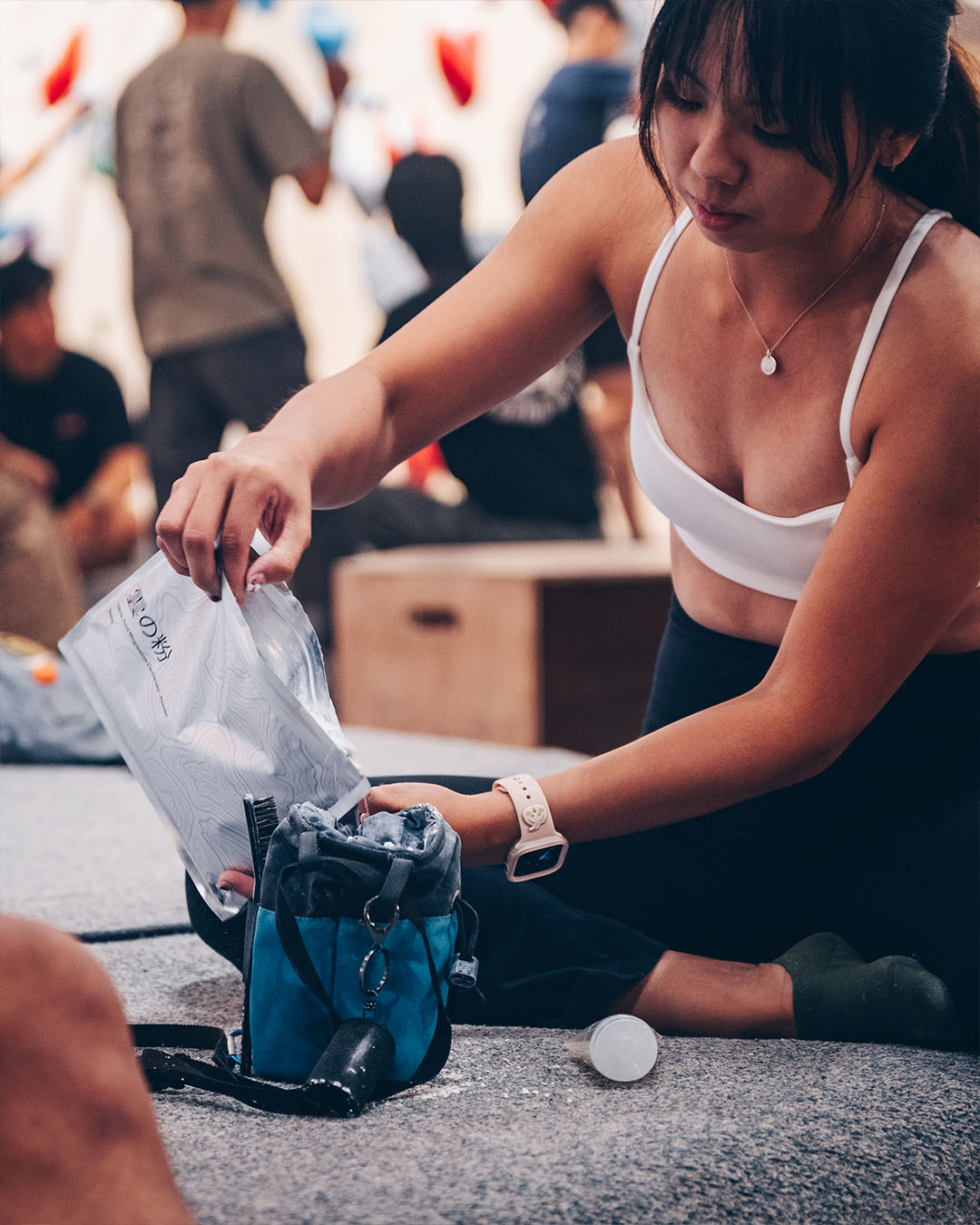 Climber looking down at chalk bag in a climbing gym
