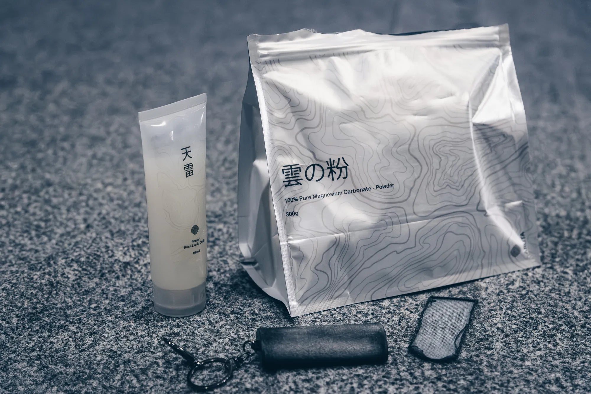 Thunder liquid chalk, Kumo powder chalk bag, and Razure skin file laid out on a granite surface