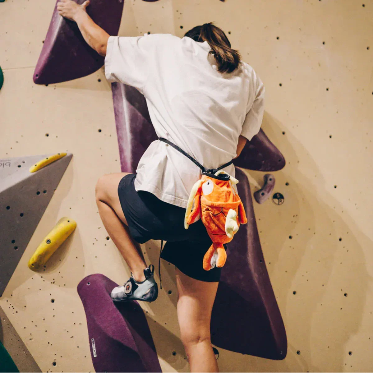 Female Climber with Novelty Chalk Bag on Boulder Wall